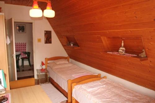 バラトンギュルクにあるHoliday home in Vonyarcvashegy 20268の木製の壁のベッドルーム1室(ベッド2台付)