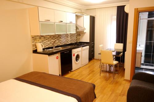 une chambre avec un lit et une cuisine avec un lave-linge dans l'établissement Sheriff Residence, à Istanbul