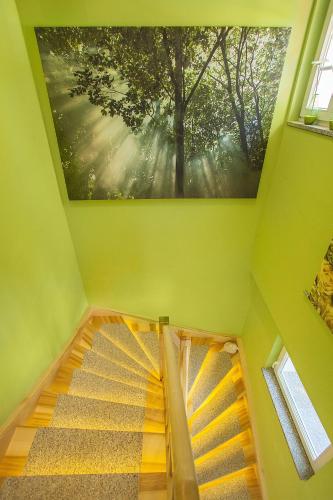 a painting of a tree on the ceiling of a staircase at City-Appartements Am Wall in Goslar