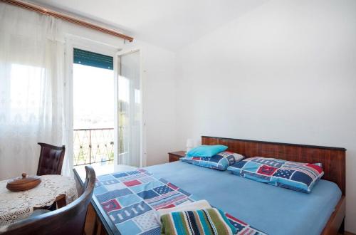a bedroom with a bed and a table and a window at Holiday home Zlarin 1 in Zlarin