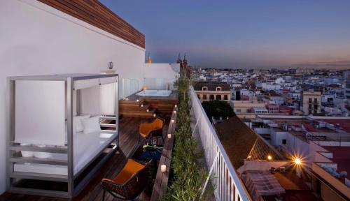 a balcony with chairs and a view of a city at Hotel Colón Gran Meliá - The Leading Hotels of the World in Seville