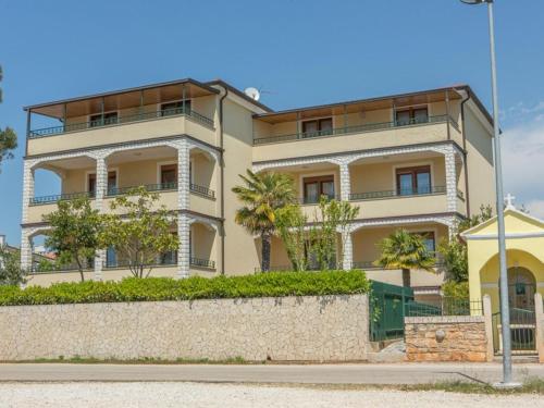 un gran edificio blanco con árboles delante de él en Villa Julia, en Lovrečica