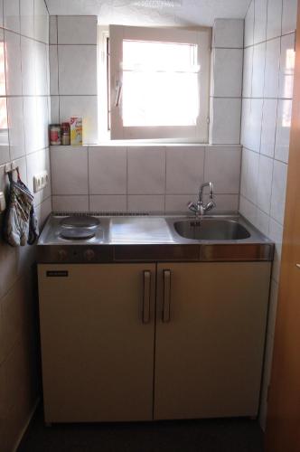 eine kleine Küche mit einem Waschbecken und einem Fenster in der Unterkunft Apartment Neuendorf - Hiddensee 1 in Neuendorf