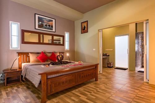 1 dormitorio con 1 cama grande y espejo grande en Koh Mak White Sand Beach, en Ko Mak