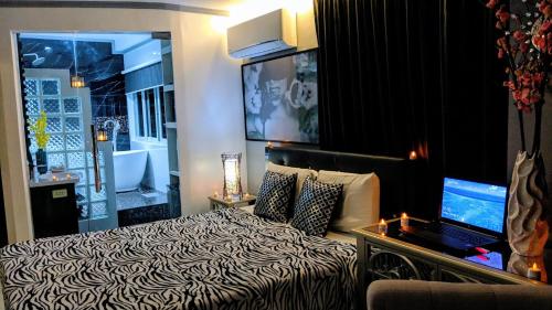 a bedroom with a bed and a laptop on a table at Bohol South Beach Hotel in Panglao
