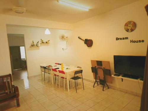 d'une salle à manger avec une table, des chaises et une télévision. dans l'établissement Wong Bentong Makmur Homestay, à Bentong