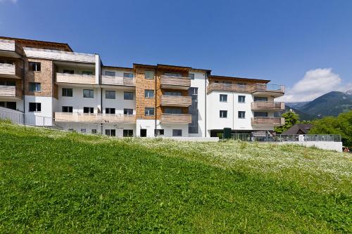 a building on top of a hill with a green field at Appartement Klosterhügel in Haus im Ennstal