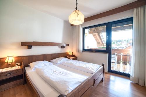 a bedroom with a large bed and a large window at Sonnen Residence in Collalbo