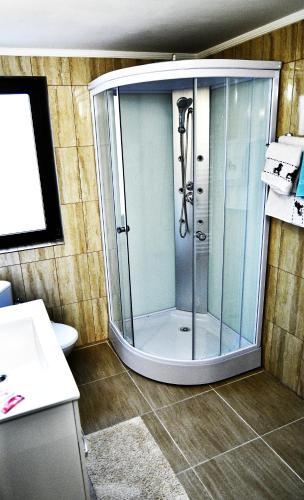 a shower with a glass door in a bathroom at Upstairs Residence in Târgu Jiu