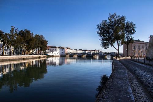 a view of a river with a bridge and buildings at Casa Amarela in Tavira