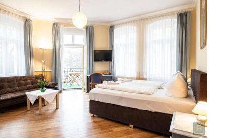 a bedroom with a large bed and a living room at Hotel Silesia in Görlitz