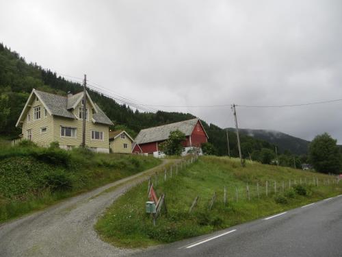 a house on a hill next to a road at Tiny house with Fjordview! in Lauvstad