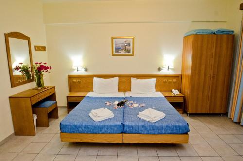 a hotel room with a bed with two towels on it at Stella Hotel in Pefki Rhodes