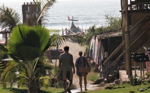two people walking down a path towards the beach at Lotus Sutra Beachfront Resort in Arambol