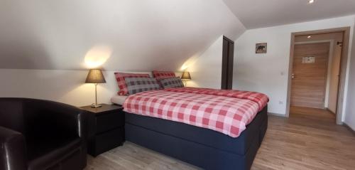 una camera con un letto con una coperta rossa a scacchi di Gästehaus Behabühl a Feldberg