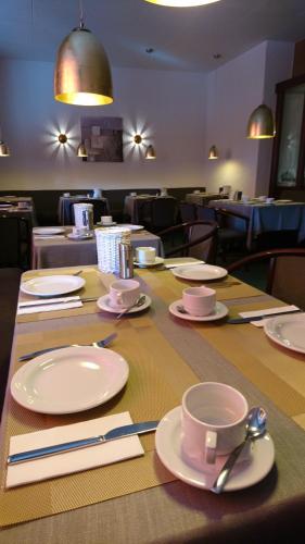 a table with plates and cups and napkins on it at Hotel Deutschherrenhof in Trier
