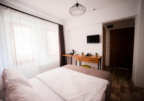 a bedroom with a bed and a desk and a window at Set Özer Hotel in Çanakkale