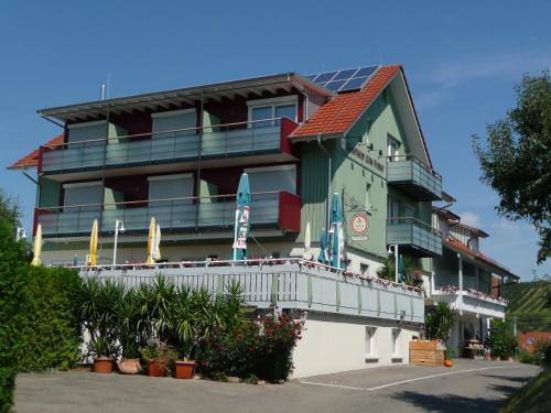 um prédio com varanda com guarda-sóis em Gasthof Brennerei zum Forst em Kressbronn am Bodensee