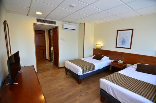Tur Hotel Santiago tesisinde bir odada yatak veya yataklar