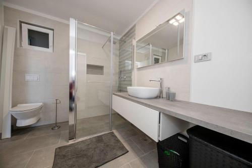 a bathroom with a sink and a toilet at VILLA LIDIA in Mundanije