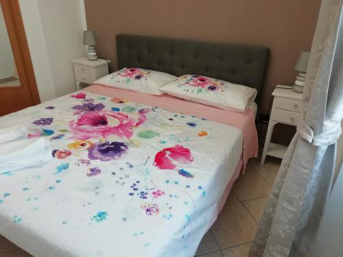 a bedroom with a bed with flowers on it at Casa SereTina in Rome