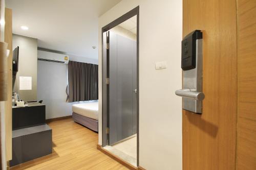 a room with a mirror and a door with a bed at Mybed Sathorn Hotel in Bangkok