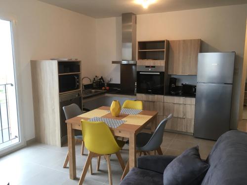 une cuisine avec une table et des chaises jaunes dans l'établissement RESIDENCE A MORTELLA - LIEU DIT TETTOLA, à Saint-Florent