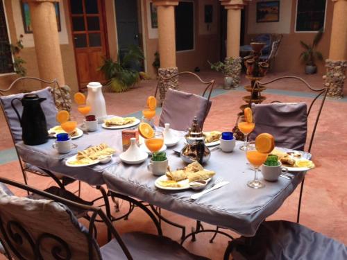 a table with plates of food and drinks on it at Riad Nkob in Nkob