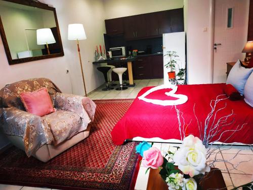 a living room with a red bed and a chair at Sweet Home Suite in Korinthos