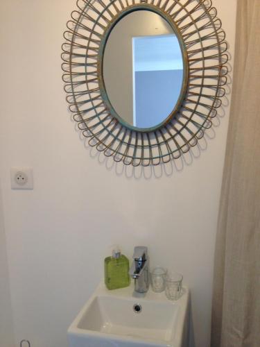 a bathroom with a mirror above a sink at Idées Déco At Home in Verneuil-sur-Seine