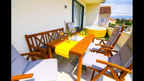 a wooden table and chairs on a balcony at Holiday home Velebit in Nin
