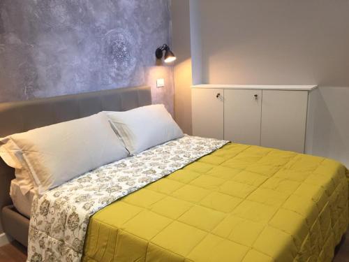 a bedroom with a bed with a yellow blanket at Europa Apartment in Tirana