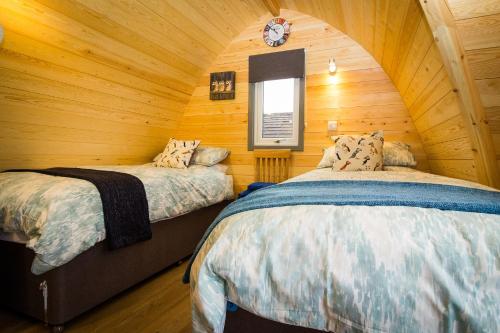 1 dormitorio con 2 camas en una cabaña de madera en Evelix Pods Dornoch en Dornoch