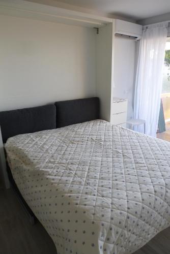 une chambre avec un lit avec une couette blanche dans l'établissement Les Terrasses de la Mer, à Menton