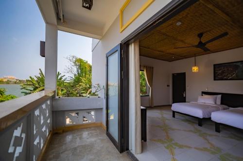 a bedroom with a view of the water at Hoi An Corn Riverside Villa in Hoi An