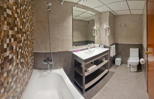 a bathroom with a sink and a tub and a toilet at Voramar Cambrils in Cambrils