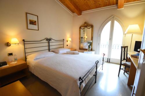 a bedroom with a large bed and a large window at Palazzo Sottile Meninni in Gravina in Puglia