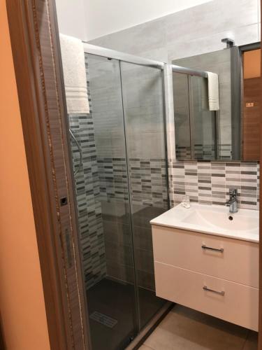 Un baño con ducha de cristal y lavabo. en STABILE139, en Palermo