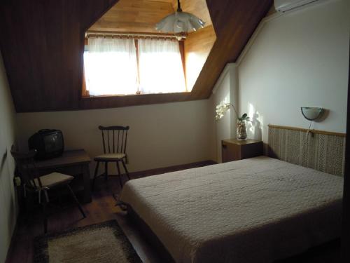 ボニャルツバシュにあるThomas vendégházのベッドルーム1室(ベッド1台、窓、椅子付)