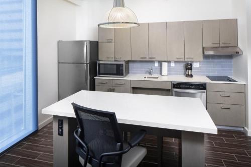 a kitchen with a white counter and a refrigerator at Hyatt House Nashville at Vanderbilt in Nashville