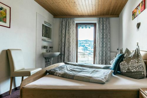 um quarto com uma cama, uma janela e um lavatório em Appartement Mangeng em Bartholomäberg