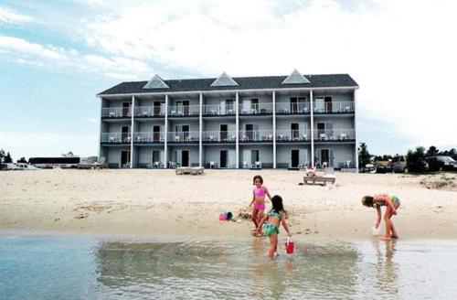 麥基諾城的住宿－濱水華美達酒店，一群儿童在海滩上玩耍