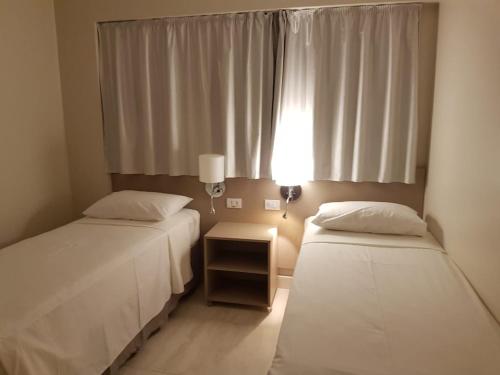 two beds in a small room with a window at SALINAS PARK RESORT - Melhor Resort do Norte in Salinópolis