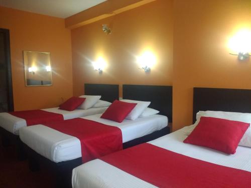 a hotel room with three beds with red pillows at Hotel La Herreria Colonial in Popayan