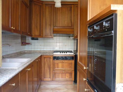 Una cocina con gabinetes de madera y un horno de estufa. en Casa da 2 a 7 posti nelle Piccole Dolomiti, en Recoaro Terme