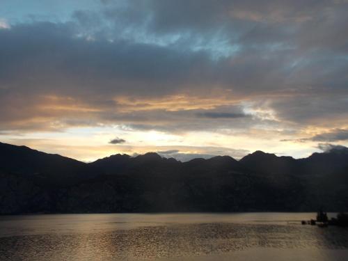 a sunset over a lake with mountains in the background at B&B Casa Sartori in Malcesine