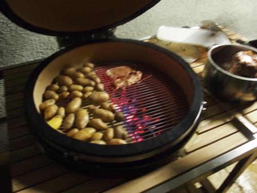 a grill with potatoes and food inside of it at Dorfergut in Weisspriach