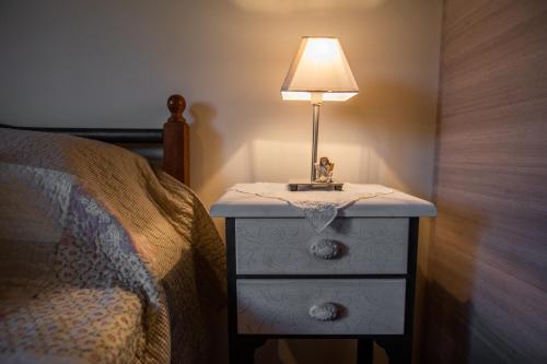 a nightstand with a lamp on it next to a bed at Chrysianna seaview apartment in Argostoli