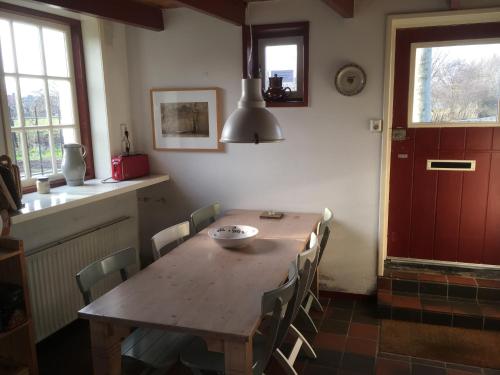 a kitchen with a wooden table and chairs in a room at 8 Jonkvrouw Geilstraat in Sluis