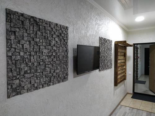 Habitación con TV en la pared en Milo Apart Hotel, en Karagandá